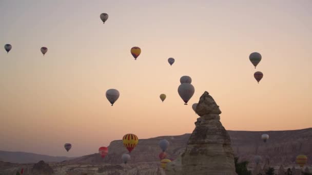 Balon udara berwarna mengapung di atas pegunungan tua saat matahari terbit — Stok Video