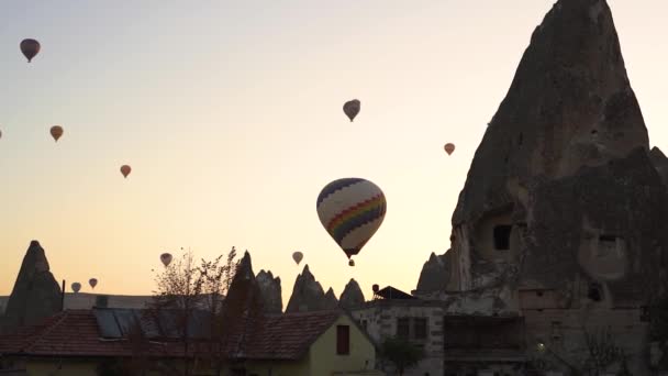 Afstandelijke heteluchtballonnen zweven in de lucht boven de oude stad — Stockvideo