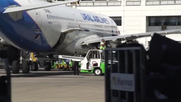 Luchthaven werknemer in vest loopt langs boarding transporter — Stockvideo
