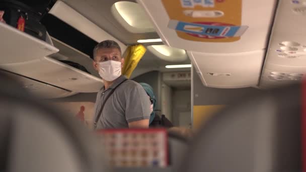Tıbbi maskeli yolcular el bagajlarıyla kabine girerler. — Stok video