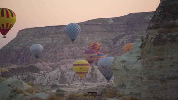 Fantastiska ballonger med korgar flyter i luften ovanför kullar — Stockvideo