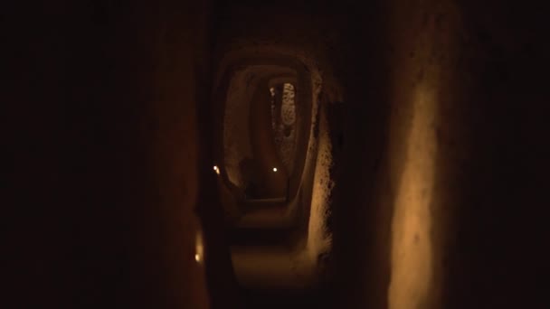 Rörelse längs smal halvark handgjord grotta tunnel med lampor — Stockvideo