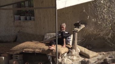 Yaşlı Arap adam geleneksel Türk evinin yakınında oturuyor