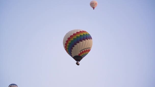 Colorido globo de aire caliente flota en el cielo despejado al amanecer — Vídeo de stock