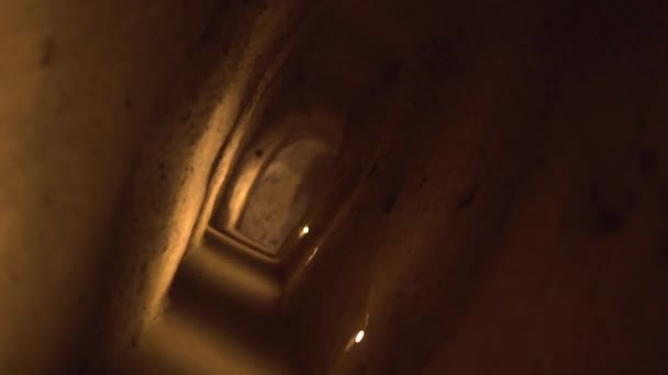 Câmera se move girando ao longo estreita caverna artesanal semi-escura — Vídeo de Stock