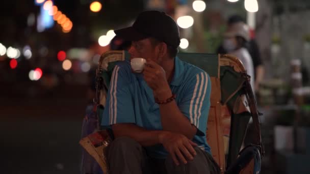 티셔츠를 입고 하얀 컵에서 커피를 마시고 있는 이 지역 남자는 — 비디오