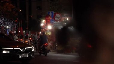 Arabalar ve motosikletler asfalt yolda pazara karşı sürüyorlar.