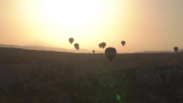 Grandes siluetas de envoltura de globo de aire caliente flotan al amanecer — Vídeo de stock