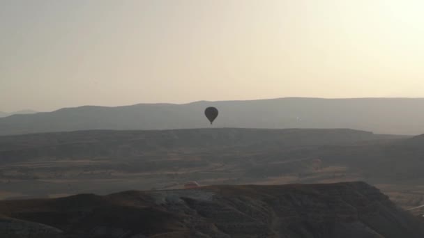 Büyük sıcak hava balonu silueti sisli arazide uçuyor. — Stok video