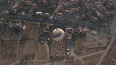 Büyük sıcak hava balonu kahverengi çatıların üzerinde uçar.