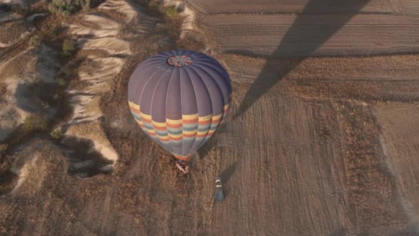 Ballon à air chaud avec une grande enveloppe colorée atterrit sur le terrain — Video