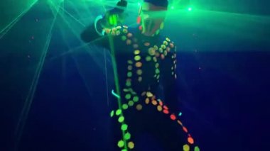 Gece kulübünde animatör yeşil ışıklarla dans ediyor.