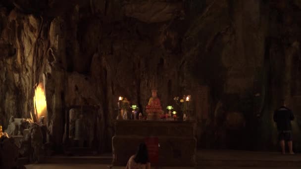 Kobieta modli się do buddyjskiego świętego pod ogromnym posągiem Buddy — Wideo stockowe