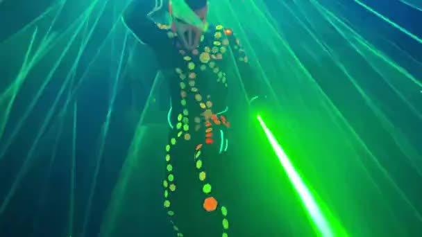Danser in fluorescerend kostuum en masker voert laser show — Stockvideo