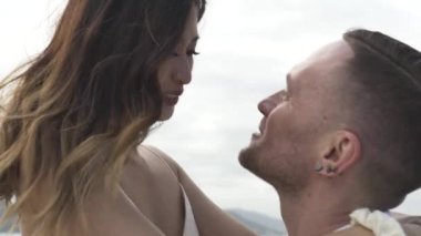 Mutlu adam, denizde yelken açan güzel Asyalı kız arkadaşını tutuyor.