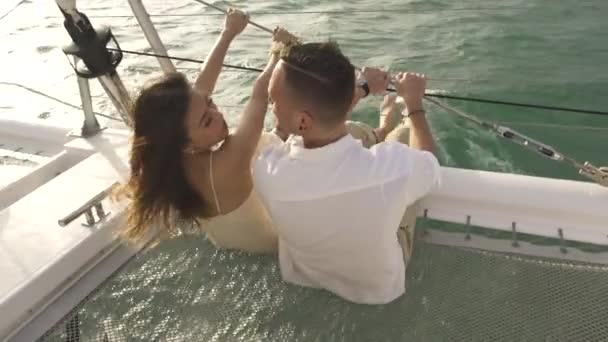 Família casal beijos sentado no trampolim net de iate — Vídeo de Stock