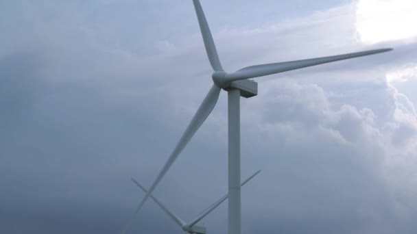 Las grandes cuchillas grises giran en la fila de molinos de viento del generador de energía — Vídeo de stock