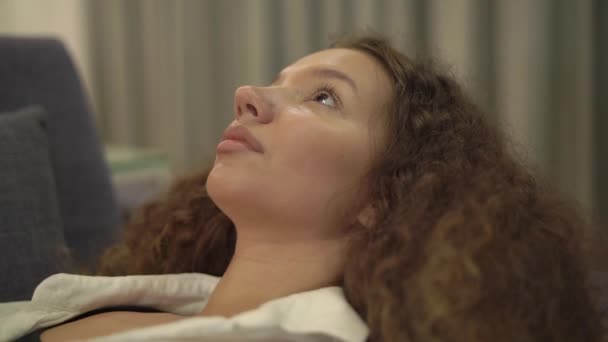 Nachdenkliche junge Frau mit lockigem Haar starrt zur Decke — Stockvideo
