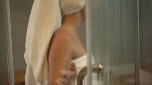 Mischlingshündin in weißen Handtüchern betritt Sauna und setzt sich — Stockvideo