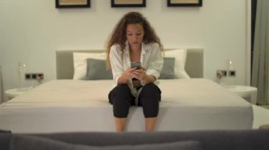 Telefondaki uzun saçlı, konsantre bir esmer.