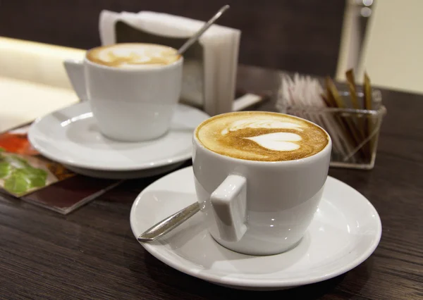 Deux tasses de cappuccino dans un style romantique servi dans un café — Photo