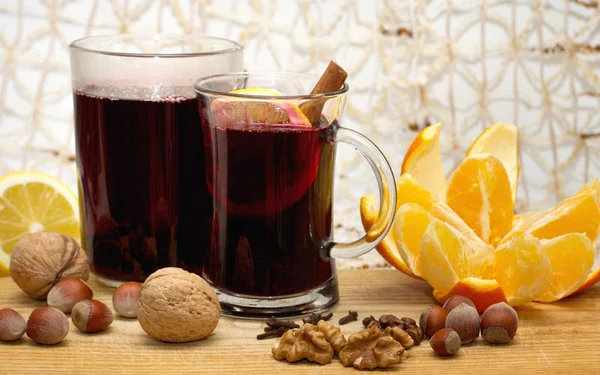 iki bardak mulled şarap, limon, portakal ve ceviz ahşap tablo