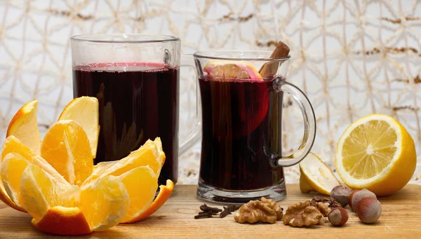 iki bardak mulled şarap, limon, portakal ve ceviz ahşap tablo