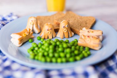 Funny sausages with peas and bread clipart