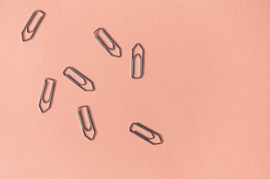 Pastel pembe arka planda metal ataçlar. Ofis teması. Düz yatıyordu.