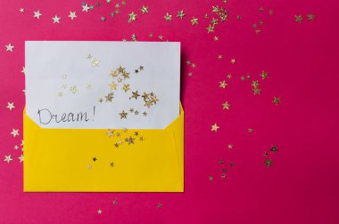 Dilekleri olan sarı bir zarf. Yıldız pulları. Dileklerle dolu bir zarf. Kutlama zarfı. Ortasında hayaller olan bir zarf. Düz yatıyordu.