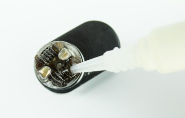 Close-up of dripping juice on the coils of an e-cigarette clipart