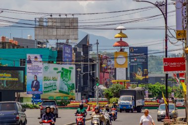 Bandar Lampung, Endonezya - 11 Aralık 2025: Bandar Lampung, Endonezya 'da reklam panoları ve Adipura Anıtı ile yoğun sokak trafiği