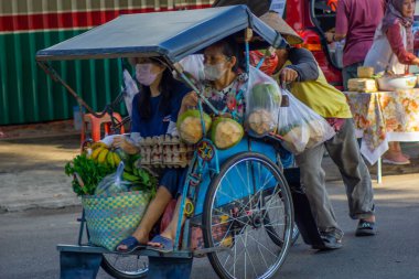 Bandar Jaya, LampungJune 22, 2025: Şehirde yolcu ve bakkaliye taşıyan geleneksel Endonezya becak rickshaw 'u