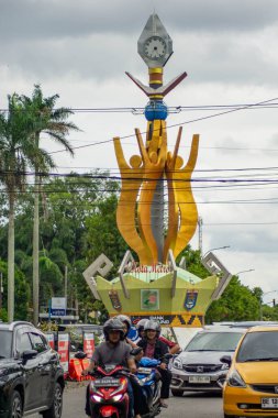 Metro, Lampung - 31 Aralık 2025: Tuğu Pena, Lampung, yoğun trafik ile çevrili bir şehir anıtı.