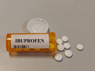 Masaya konmuş plastik ibuprofen tabletleri, günlük kullanımda iltihap önleyici ağrı kesici..