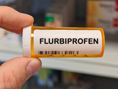 Acıyı ve iltihabı hafifletmek için kullanılan hastane eczanesinin üzerindeki FLURBIPROFEN tabletlerinin turuncu plastik kutusu. PHARMACY Deposu