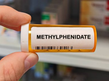 Hiperaktivite uyarıcısını tedavi etmek için kullanılan bir hastane masasının üzerindeki turuncu plastik kutu METHYLPHENIDATE tabletleri. PHARMACY Deposu