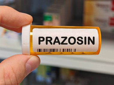 PRAZOSIN tabletlerinden oluşan turuncu plastik kutu yüksek kan basıncı ve travma sonrası stres bozukluğunu tedavi etmek için kullanılan bir hastane masasının üzerinde. PHARMACY Deposu