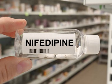 Box of NIFEDIPINE tablets on a hospital pharmacy table used to treat high blood pressure and angina a calcium channel blocker.