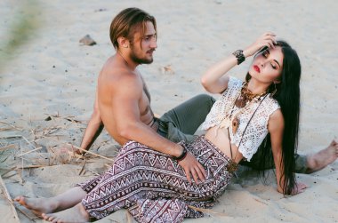 woode sahilde kum üzerinde oturan güzel genç Çift