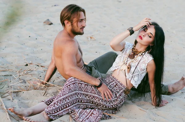 woode sahilde kum üzerinde oturan güzel genç Çift