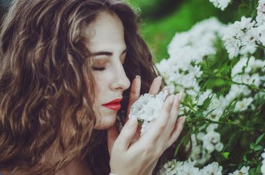 uzun dalgalı saçlı uzun beyaz bir elbise genç güzel kadın,