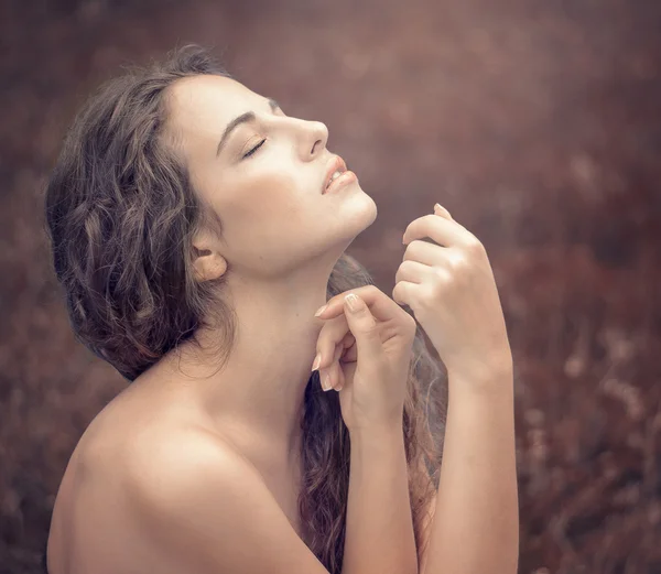 Bela jovem mulher em um vestido branco longo com cabelo ondulado longo , — Fotografia de Stock