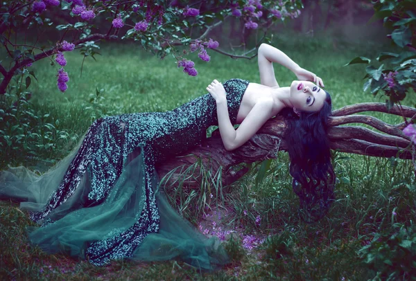 Hübsches schlankes Mädchen mit dunklen Haaren in einem langen smaragdgrünen Kleid — Stockfoto