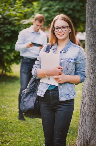 Felice carino giovane studentessa sorridente nel parco con libri e — Foto Stock
