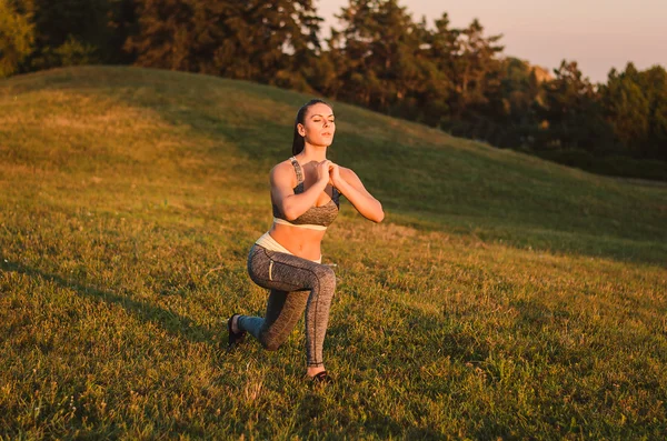 Aantrekkelijke fitness vrouw oefenen in het park op het gras. Het — Stockfoto