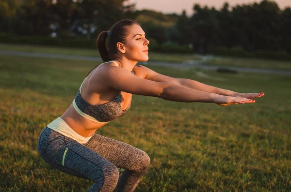 Aantrekkelijke fitness vrouw oefenen in het park op het gras. Sh — Stockfoto