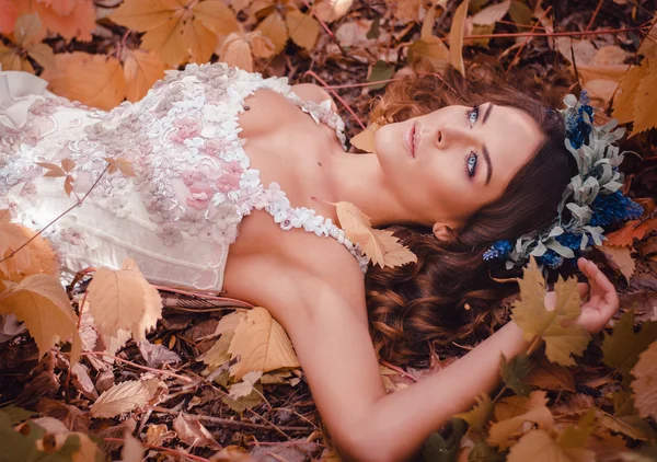 Hermosa mujer de cabello castaño en una corona de flores —  Fotos de Stock