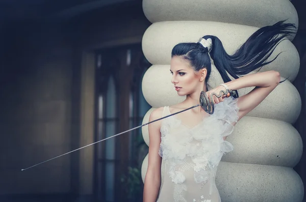 Portrait d'une belle fille dans une robe blanche avec une épée à la main . — Photo