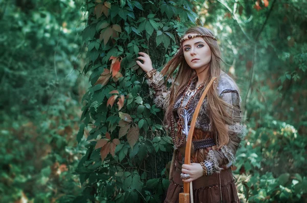 Woman hunter with a bow in hand in the forest. Amazon with a bow in the hands of the forest. — Stok fotoğraf